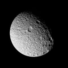 На освещённой стороне Мимаса отчётливо видны кратеры различных размеров.