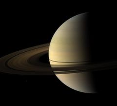 Мимас на фоне Сатурна (маленькая белая точка слева внизу изображения, нажмите на изображение для увеличения).