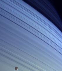 Мимас на голубом фоне северных широт Сатурна.